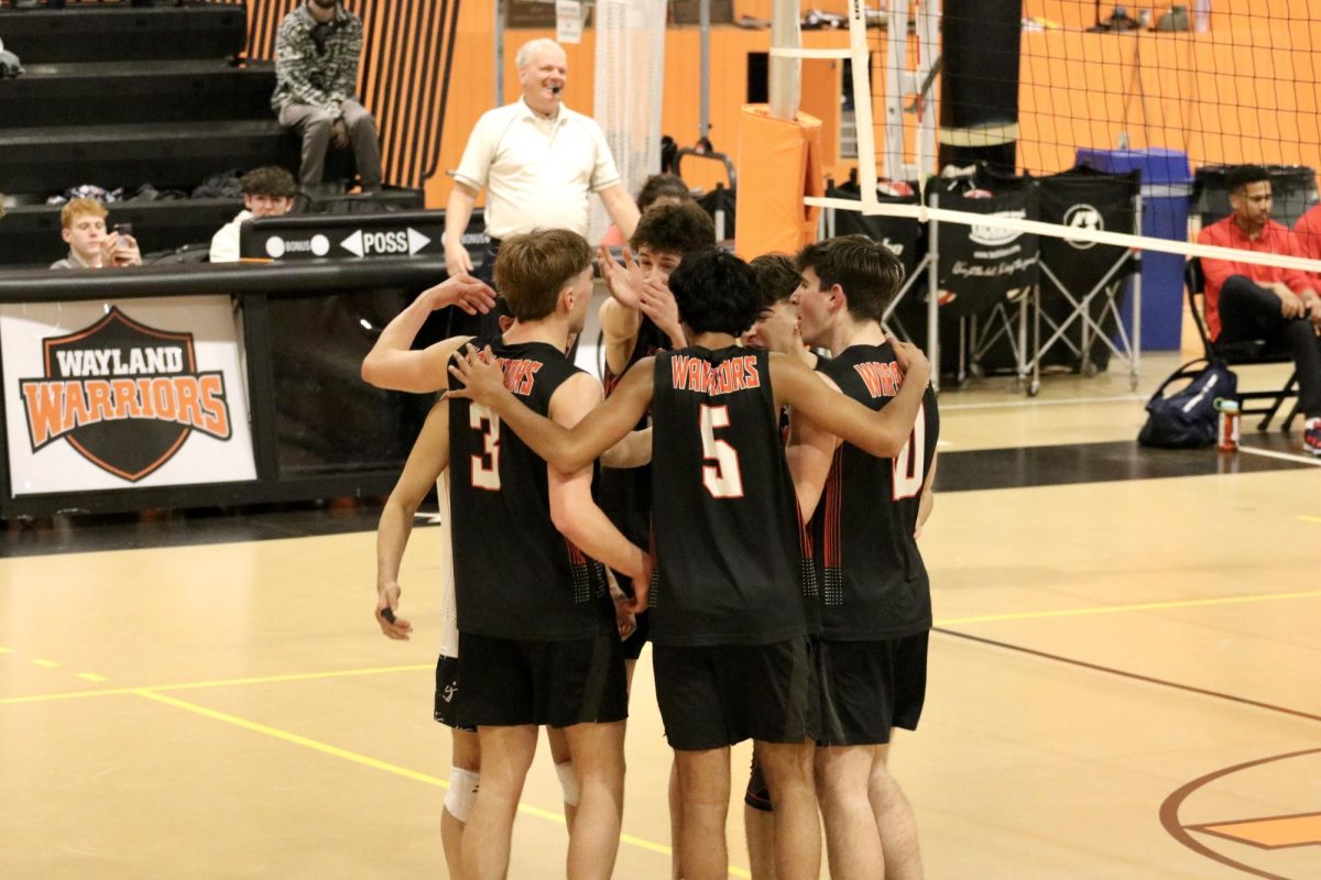 During a game against Brookline High School, players circle to celebrate senior captain Finn Bell's ace.