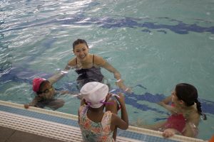 Sophomore Izzy Irwin smiles as she talks to Water Warrior swimmers and sophomore Maddie Hartford. Irwin has been volunteering in the program since her freshman year and is on the WHS girls swim and dive team.