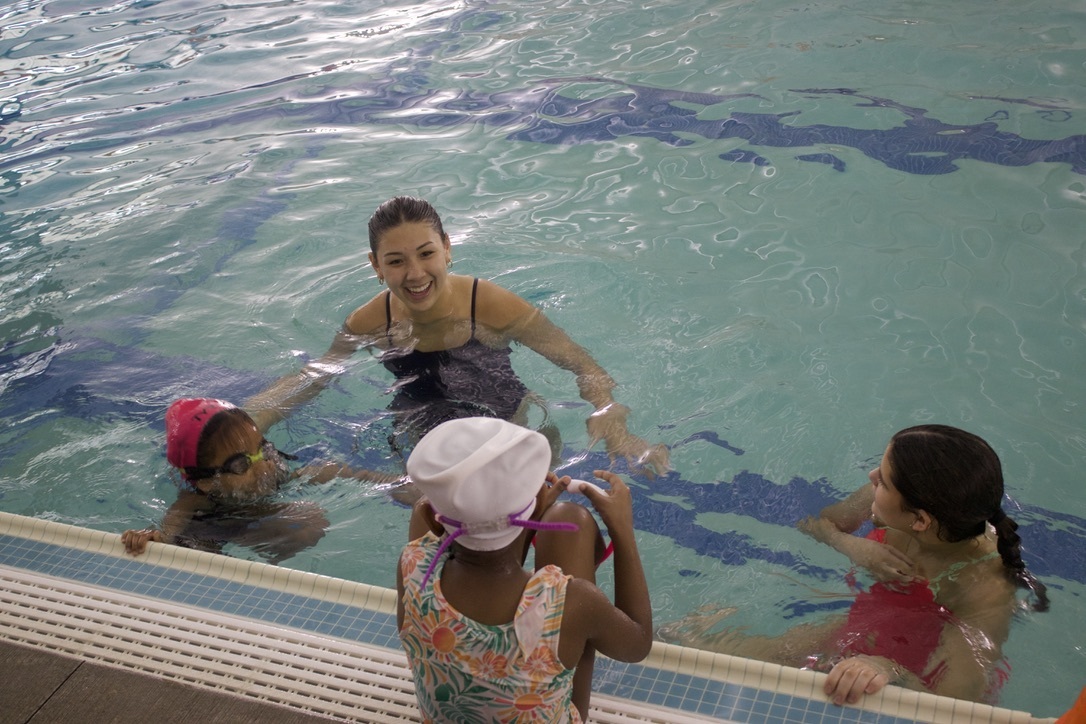 Sophomore Izzy Irwin smiles as she talks to Water Warrior swimmers and sophomore Maddie Hartford. Irwin has been volunteering in the program since her freshman year and is on the WHS girls swim and dive team. 
