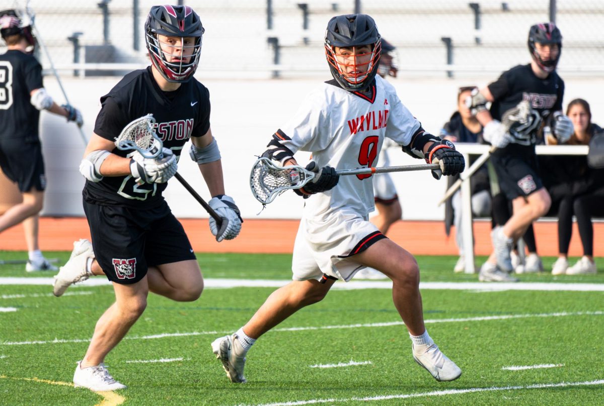 Senior captain Cole Zachery looks towards his teammate to receive the ball while a Weston defender is chasing after him.