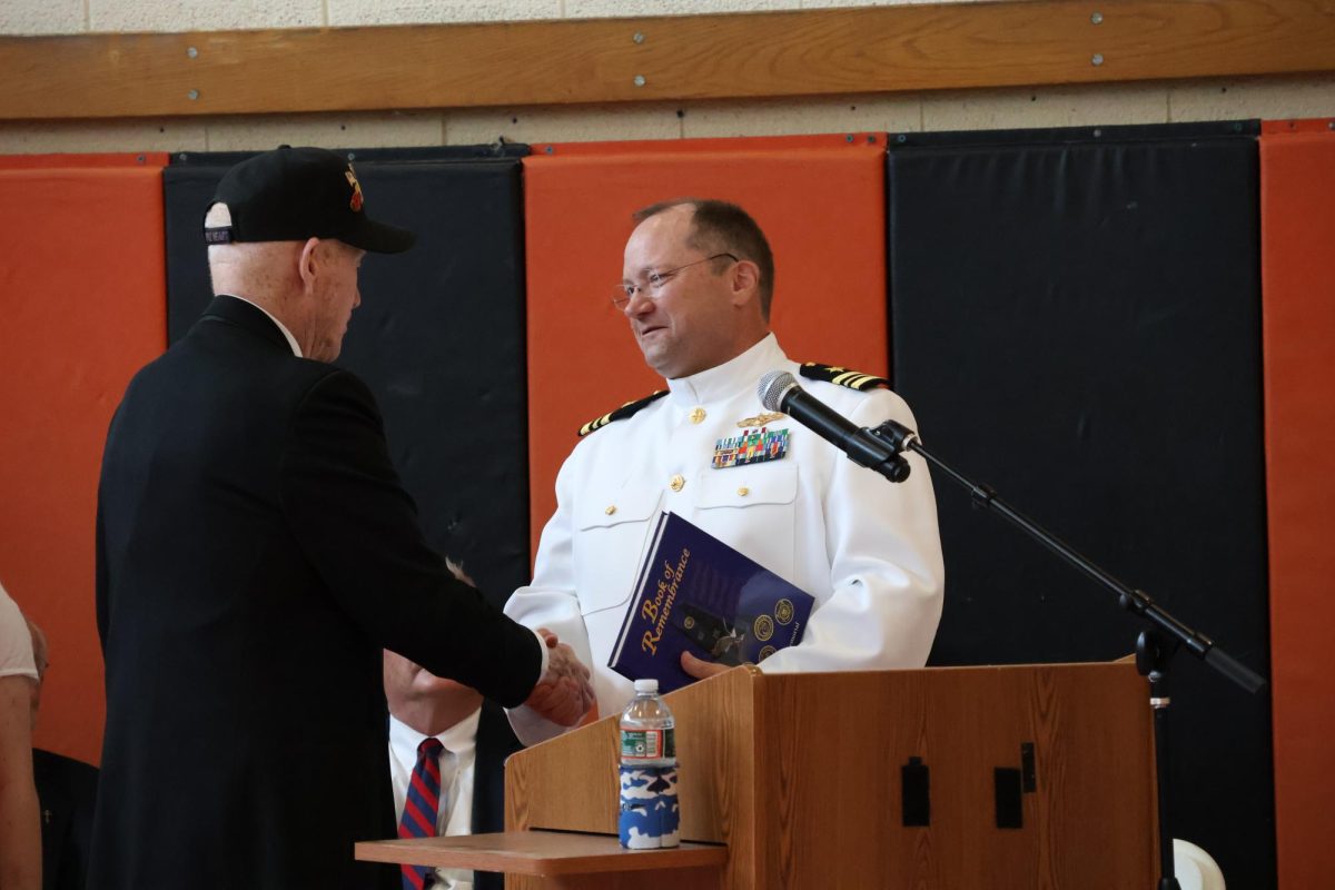 Keynote speaker Graig Gruber - who currently serves in the United States Navy - shakes hands with Richard Turner before beginning his speech.