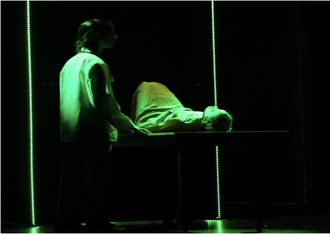 Grace Fryer (Lily Rose Hage) lays on the examination table as Dr. Joseph Knef (Jake Sherman) examines her jaw, giving a prognosis favorable to the company. 