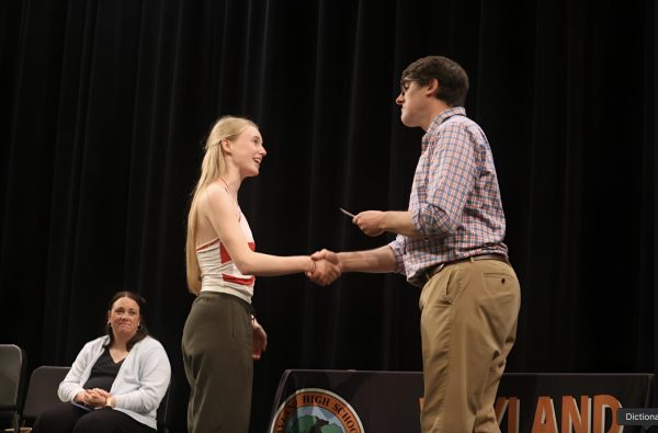 Junior Madita Hofmann smiles as she receives an award from English Department Head Peter Galalis.